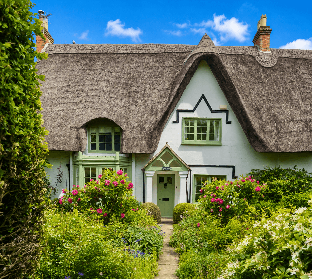 Traditional English country home surrounded by mature trees and gardens providing natural shade during summer